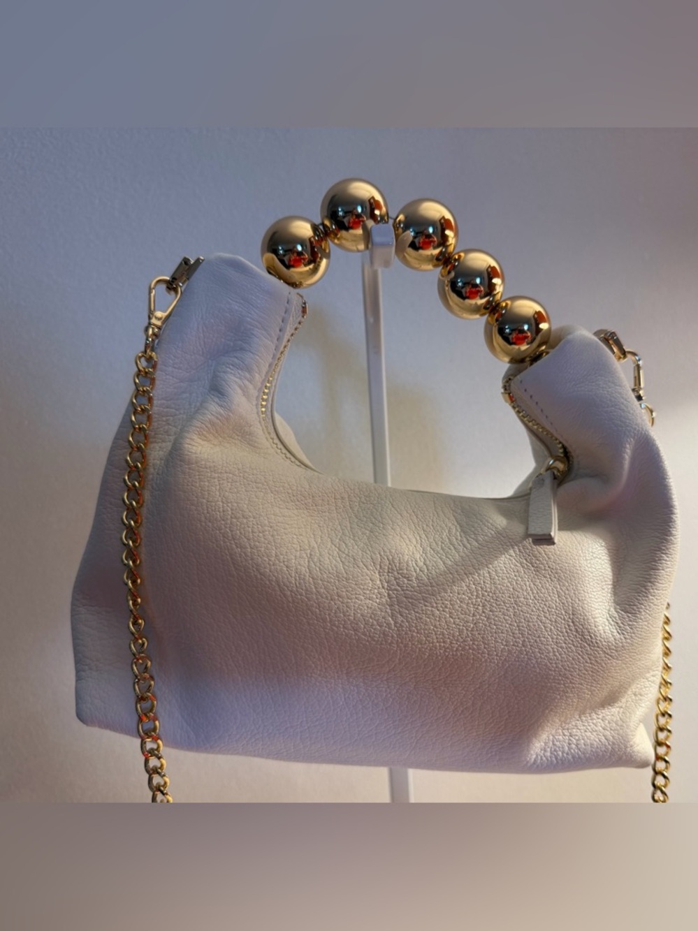 Doris & Jacky mini white leather bag with metal ball handle and chain crossbody.